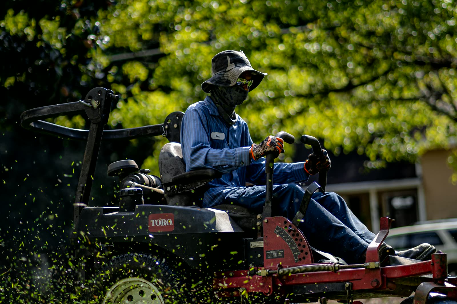 A crew member mowing a lawn